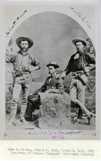 Black and white photo of three men wearing hats