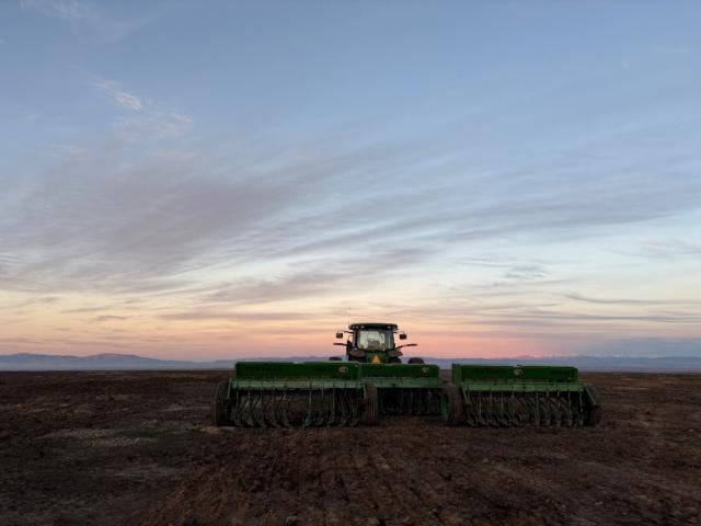 Tractor pulling Range Master drills while seeding across the Range Fire burn scar. Photo courtesy of BLM.