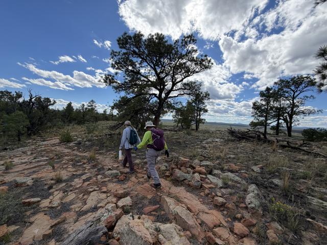 Two hikers traverse the Narrows Rim Trail.