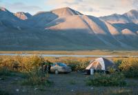 Tent and car in front of mountain