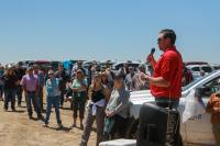 One person speaking to a group in the outdoors