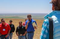 One person talking to a group of people in the outdoors