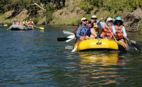 People wearing hats rafting down a river. 
