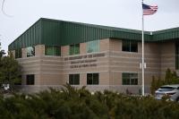 A brick building that is home to the Nevada State Office for the Bureau of Land Management located in Reno, Nevada sits behind the U.S. flag as the sun rises.