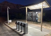 A lighted kiosk is shown at night with detailed instruction boards provides directions to visitors on how to use the new cashless self pay system