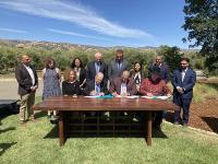 People around a table signing a document