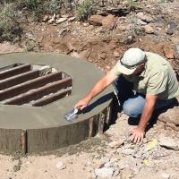 a worker smooths concrete on a mine enclosure