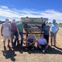 Volunteers pose in front of a sign after completing work at Painted Hand Trailhead in Canyons of the Ancients NM on National Public Lands Day 2023.