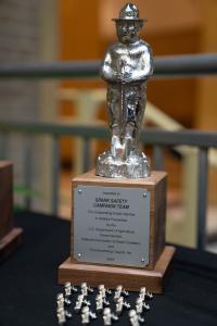 Closeup of trophy with a silver "Smokey Bear" figure on top.