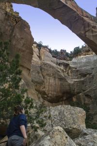 A visitor gazing up at La Ventana Arch in the El Malpais National Conservation Area.