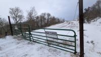 A gate with a "road closed" sign on a snowy road. 