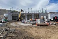 A large cinderblock building midway through construction in the high desert.