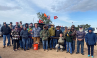 Volunteers pose in front of off-road vehicle