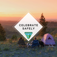 Photo of two people camping at sunset, sitting in two chairs with a dog sitting in between them with a graphic over top saying "Celebrate Safely"