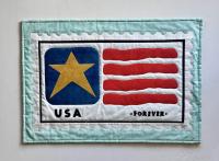 Quilted fabric artwork resembling a USA postage stamp with a gold star, red stripes, and "USA" and "FOREVER" text.
