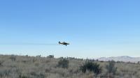 Image of airplane flying spraying herbicide across rangeland