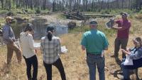 photo of RAC members meeting in a forest near a stream
