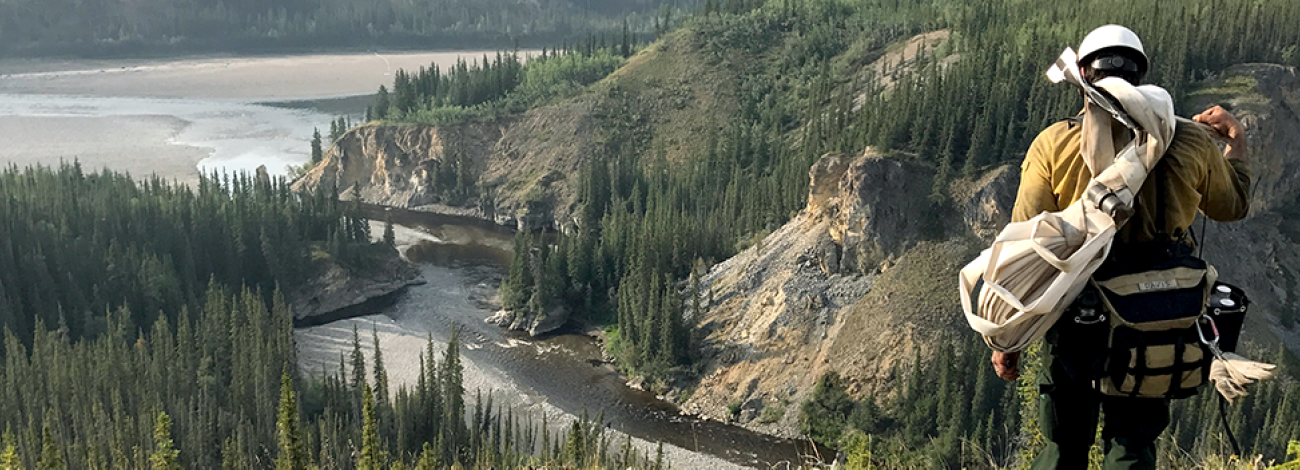 Firefighter walking on mountain overlooking two rivers