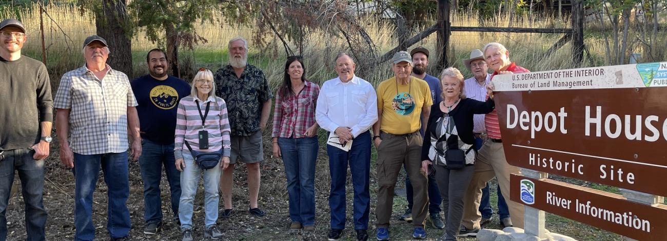 group of RAC members posing near a BLM sign reading Depot House Historic Site