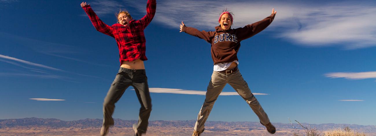 Two interns jump in the air in celebration.