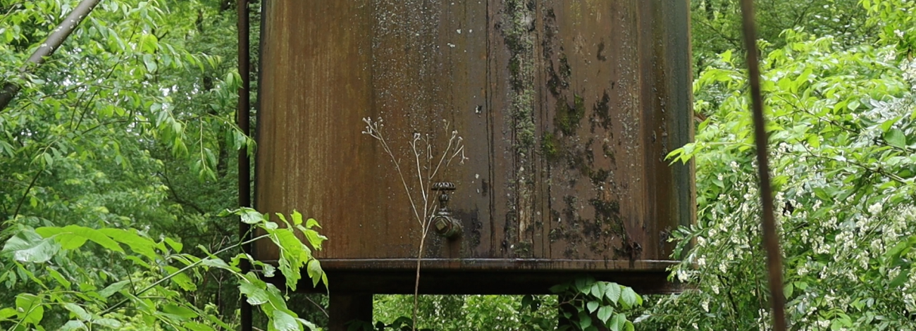 A large rusting tank, part of an orphaned well, stands in heavy forest near the Shenango River Lake in northwestern Pennsylvania.