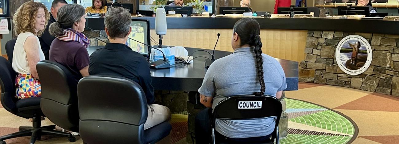 a photo of five people sitting in front of a Tribal council