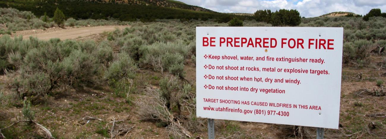 A sign on a sagebrush landscape reading BE PREPARED FOR WILDFIRE