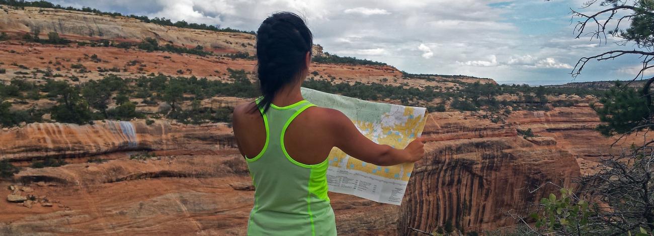 person reading a map with view of mule canyon in the background