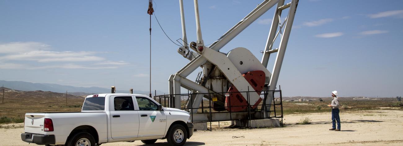 A BLM pickup truck is parked in front of an oil jack in California