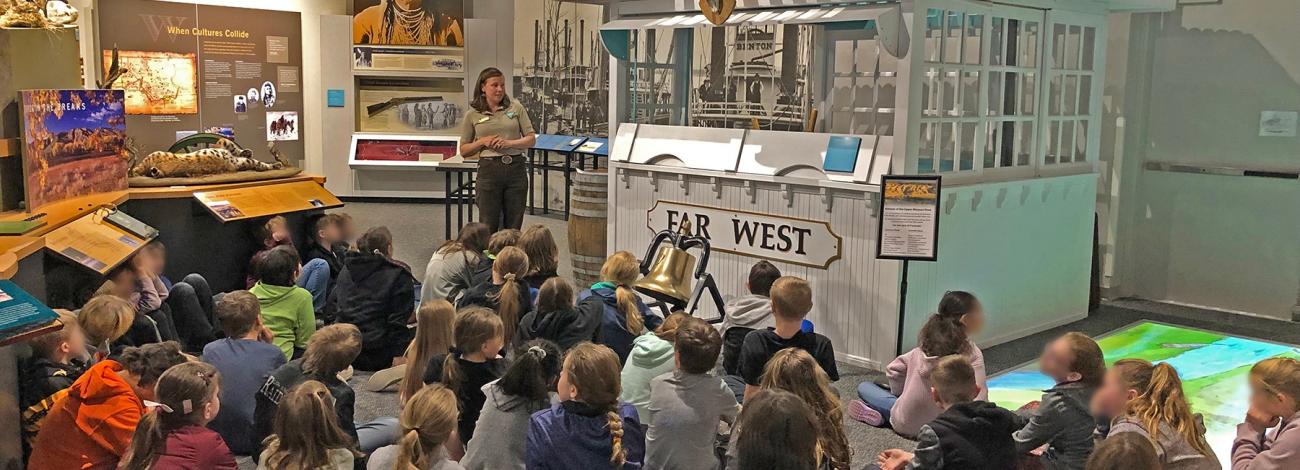 Students sit on the floor listening to a Ranger Program in the Missouri Breaks Interpretive Center