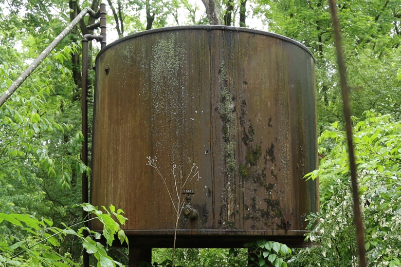 A large rusting tank, part of an orphaned well, stands in heavy forest near the Shenango River Lake in northwestern Pennsylvania.