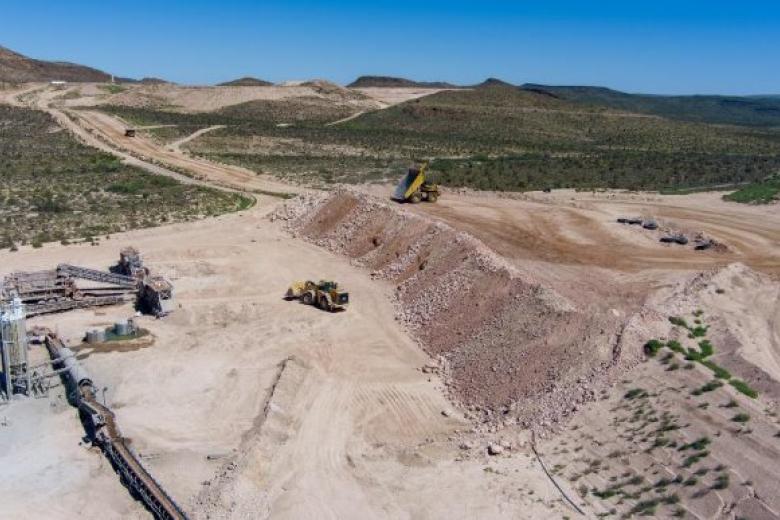 A aerial shot of an open pit mine in the desert.