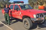 Firefighter Adam Kohley standing next to a training support truck