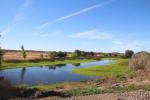 A water reservoir is surrounded by lush vegetation.  