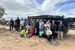 Volunteers and agency partners stand in front of a large dumpster trailer collected 3,780 pounds of garbage.  