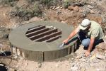 A cement worker smooths a cap on a mine