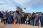 Volunteers pose in front of off-road vehicle