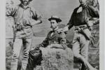 Black and white photo of three men wearing hats