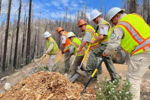 BLM and NPS maintenance crews shovel wood chips, pictured left to right: Jimmy Garcia BLM Heavy Equipment Operator, Oscar Luna NPS Crew, Kellie Greenwood NPS Crew, Adam Pegorsch NPS crew, Steve Barry NPS Crew and Arturo Casarez BLM Park Ranger.