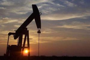 Silhouette of a pumping oil rig at sunset.