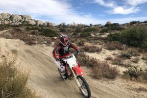 Neil Hamada on a dirt bike in the desert