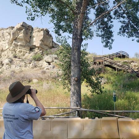 Person looking at the Pillar through binoculars. 