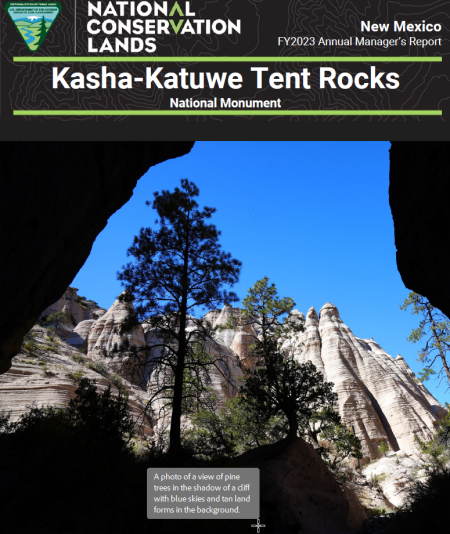 hoodoo rock formations from a cave with blue skies and silhouetted pine trees 