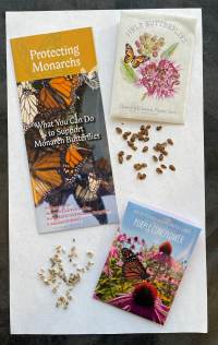 Pamphlets and seed packets for supporting monarch butterflies, with seeds scattered on white paper.